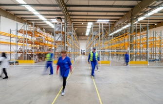 Employees walking through a warehouse aisle in a storage and distribution centre