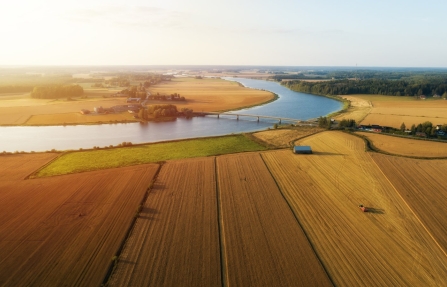 Luchtfoto van akkers langs een rivier, illustratie bij het gebruik van water in de primaire plantaardige productie